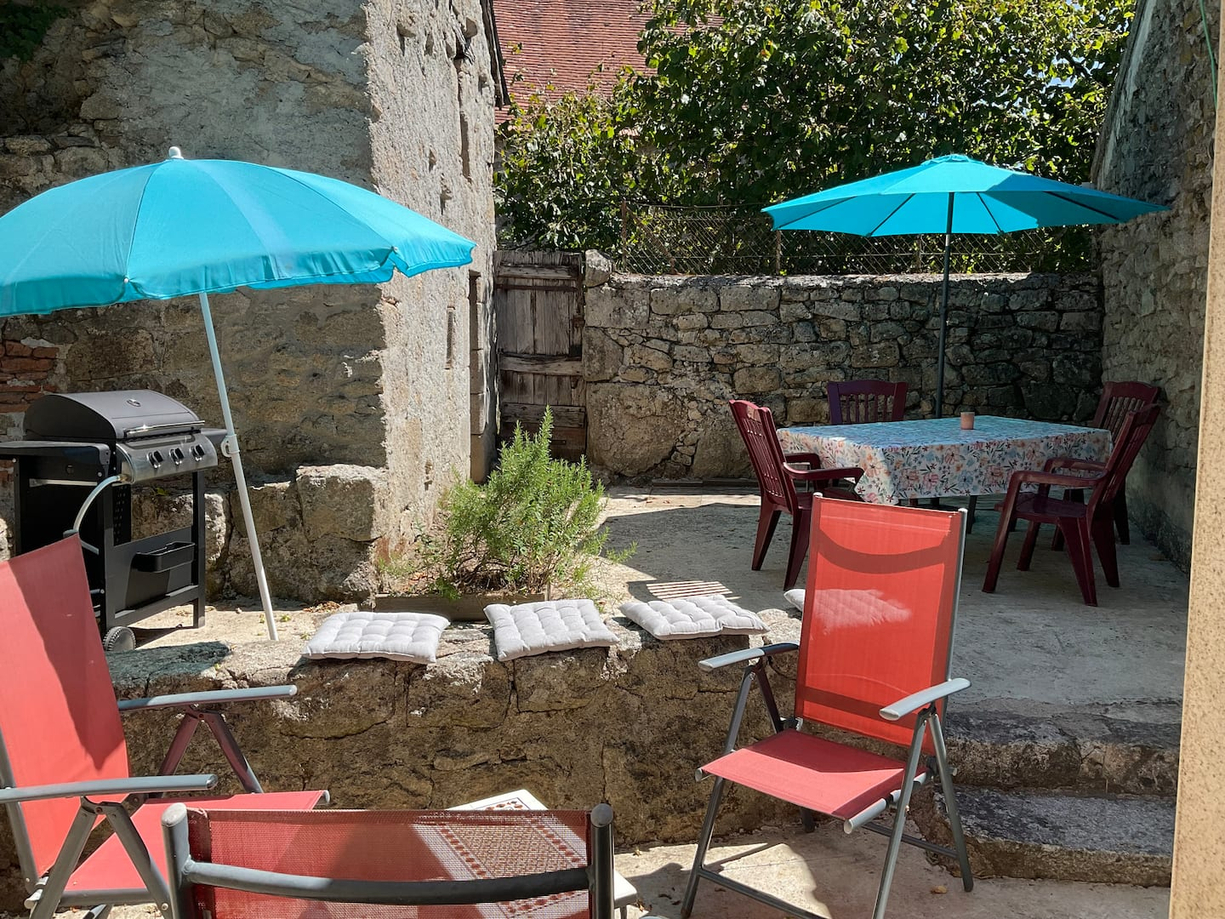 Cour extérieur avec coin détente et un espace repas avec plancha à gaz
